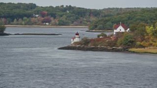 AX147_402 - 6K aerial stock footage flying by Squirrel Point Light, autumn foliage, Arrowsic, Maine