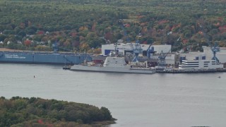 AX147_415 - 6K aerial stock footage flying away from waterfront factory, autumn, Bath, Maine