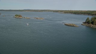 AX148_031 - 6K aerial stock footage flying by tiny islands, fishing boats, The Narrows. autumn, Waldoboro, Maine