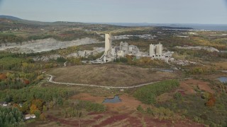 AX148_073 - 6K aerial stock footage flying by quarry and factory, autumn, Thomaston, Maine