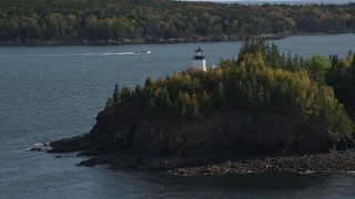 AX148_083E - 6K aerial stock footage orbiting Owls Head Light, fall foliage, autumn, Owls Head, Maine