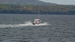 AX148_088 - 6K aerial stock footage tracking a fishing boat, colorful foliage, autumn, Owls Head, Maine