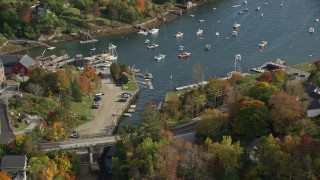 AX148_096E - 6K aerial stock footage orbiting small coastal town, Rockport Harbor, autumn, Rockport, Maine