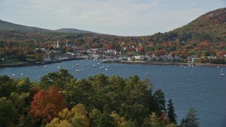 AX148_109E - 6K aerial stock footage approaching Curtis Island Light, reveal small coastal town, autumn, Camden, Maine