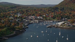 6K aerial stock footage flying by small coastal town and Camden Harbor, autumn, Camden, Maine Aerial Stock Footage | AX148_120E