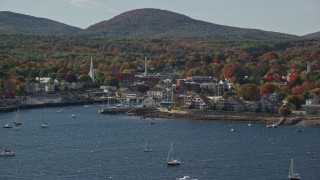 6K aerial stock footage flying by small coastal town, boats, autumn, Camden, Maine Aerial Stock Footage | AX148_122