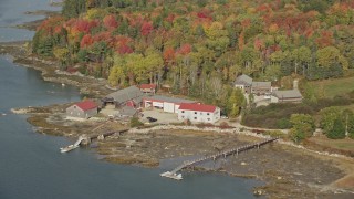 6K aerial stock footage flying by boat dealer dock and garage, forest, autumn, Brooklin, Maine Aerial Stock Footage | AX148_148E