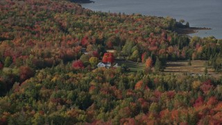 6K aerial stock footage flying by rural home, colorful forest in autumn, Brooklin, Maine Aerial Stock Footage | AX148_152E