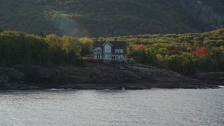 AX148_183E - 5.5K aerial stock footage approaching waterfront mansion, autumn, Bar Harbor, Maine