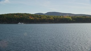 5.5K aerial stock footage flying over water toward ferry and island with fall foliage, Bar Harbor, Maine Aerial Stock Footage | AX148_209E