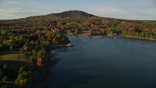 5.5K aerial stock footage flying away from coastal town among fall foliage and harbor, Blue Hill, Maine Aerial Stock Footage | AX149_022