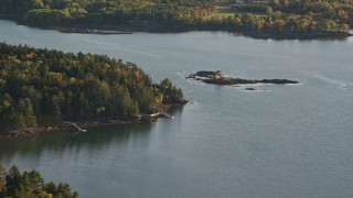 5.5K aerial stock footage flying by an isolated waterfront home, colorful trees, autumn, Penobscot, Maine Aerial Stock Footage | AX149_065