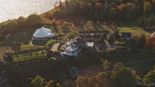 AX149_090E - 5.5K aerial stock footage flying by French's Point in front of colorful forest, autumn, Stockton Springs, Maine