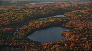 AX149_152E - 5.5K aerial stock footage flying by McClure Pond, Cain Pond, forest in autumn, Searsport, Maine, sunset