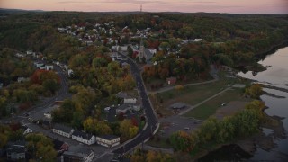 AX149_236E - 5.5K aerial stock footage flying over Northern Avenue, approach Saint Augustine Catholic Church, autumn, Augusta, Maine, twilight