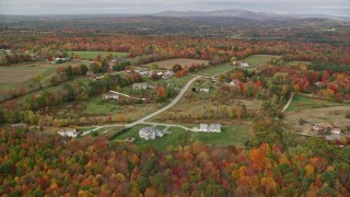 5.5K aerial stock footage flying over colorful trees, approaching farm, rural homes, autumn,Turner, Maine Aerial Stock Footage | AX150_039