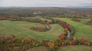 5.5K aerial stock footage flying by Nezinscot River, colorful trees, green fields, autumn, Turner, Maine Aerial Stock Footage | AX150_041