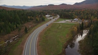 AX150_222E - 5.5K aerial stock footage flying by Highway 302, North Hampshire Department of Safety, autumn, Carroll, New Hampshire