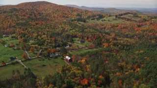 5.5K aerial stock footage approaching Pearl Lake Road, tilt down over rural homes, pond, autumn, Lisbon, New Hampshire Aerial Stock Footage | AX150_257E