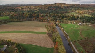 5.5K aerial stock footage flying over Ammonoosuc River, by farms, colorful trees, autumn, Lisbon, New Hampshire Aerial Stock Footage | AX150_268