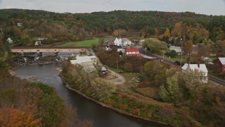 AX150_278E - 5.5K aerial stock footage approaching bridge, tilt down over church, Ammonoosuc River, autumn, Bath, New Hampshire