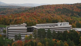 AX150_371 - 5.5K aerial stock footage orbiting office buildings surrounded by brightly colored trees, autumn, Montpelier, Vermont