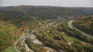 5.5K aerial stock footage flying over colorful forest, hills, approach small farms and river, autumn, South Royalton, Vermont Aerial Stock Footage | AX150_425E