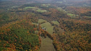 5.5K aerial stock footage flying over brightly colored forest, approaching a farm, autumn, Quechee, Vermont Aerial Stock Footage | AX150_464E