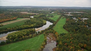 AX151_155E - 5.5K aerial stock footage approaching the Merrimack River, trees in autumn, Concord, New Hampshire