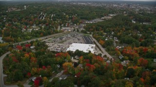 5.5K aerial stock footage flying over colorful foliage, approaching a store, tilt down, autumn, Manchester, New Hampshire Aerial Stock Footage | AX152_035