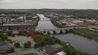 5.5K aerial stock footage flying by factories, smoke stacks, reveal and fly over small bridges, Merrimack River, autumn, Lawrence, Massachusetts Aerial Stock Footage | AX152_088E