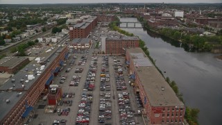 5.5K aerial stock footage orbit riverfront factories, smoke stacks, approach bridges and river in autumn, overcast, Lawrence, Massachusetts Aerial Stock Footage | AX152_091E