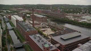 5.5K aerial stock footage orbiting factories, smoke stack, foliage near river, autumn, Lawrence, Massachusetts Aerial Stock Footage | AX152_097E