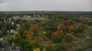 5.5K aerial stock footage flying over fall trees toward a cemetery and water tower, autumn, Lawrence, Massachusetts Aerial Stock Footage | AX152_113E