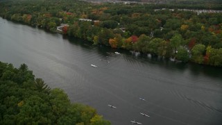 5.5K aerial stock footage flying over trees with fall colors toward a river with kayakers, autumn, Andover, Massachusetts Aerial Stock Footage | AX152_121E