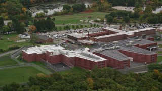 5.5K aerial stock footage of  side view orbiting a prison surrounded by trees, autumn, Billerica, Massachusetts Aerial Stock Footage | AX152_157