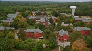 AX152_193E - 5.5K aerial stock footage orbiting Medfield State Hospital, colorful foliage, autumn, Medfield, Massachusetts