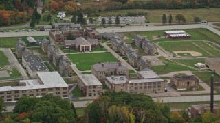 AX152_214 - 5.5K aerial stock footage flying by Massachusetts Correctional Institution at Norfolk, autumn, Massachusetts