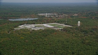 5.5K aerial stock footage of a wide view of fall foliage approaching Massachusetts Correctional Institution Cedar Junction, Walpole, Massachusetts Aerial Stock Footage | AX152_218