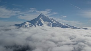 AX154_070E - 5.5K aerial stock footage of the summit of Mount Hood with snow and low clouds, Mount Hood, Cascade Range, Oregon