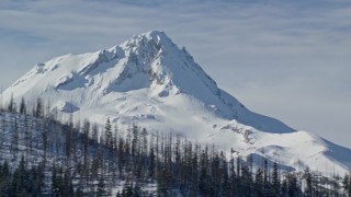 AX154_123E - 5.5K aerial stock footage of a summit of a mountain peak behind a ridge with dead evergreens, Mount Hood, Cascade Range, Oregon