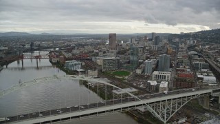 AX155_035E - 5.5K aerial stock footage orbiting the Fremont Bridge and reveal skyscrapers in Downtown Portland, Oregon