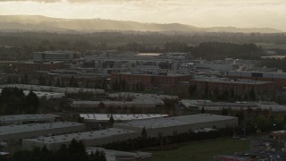 AX155_130 - 5.5K aerial stock footage of Intel Ronler Acres with godrays in the background, in Hillsboro, Oregon, sunset