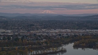 5.5K aerial stock footage of Mount Hood in the far distance at twilight, seen from a train yard in Southeast Portland, Oregon Aerial Stock Footage | AX155_169