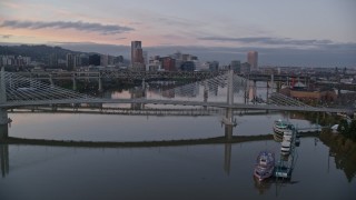 AX155_199E - 5.5K aerial stock footage fly over Tilikum Crossing, Marquam Bridge, toward downtown skyline at twilight, Downtown Portland, Oregon