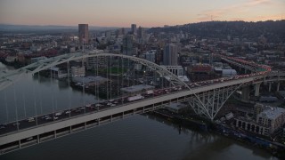 AX155_208E - 5.5K aerial stock footage orbiting heavy rush-hour traffic on both decks of the Fremont Bridge, and reveal Downtown Portland, Oregon, twilight