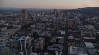 AX155_211E - 5.5K aerial stock footage flying over heavy rush-hour traffic on I-5 to approach skyscrapers Downtown Portland, Oregon, twilight