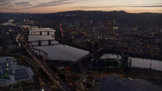 5.5K aerial stock footage flying over Moda Center, Willamette River, toward downtown skyscrapers at twilight, Downtown Portland, Oregon Aerial Stock Footage | AX155_260E