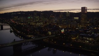 AX155_278E - 5.5K aerial stock footage fly over freeway interchange, Willamette River, Burnside Bridge, and Downtown Portland, Oregon at twilight