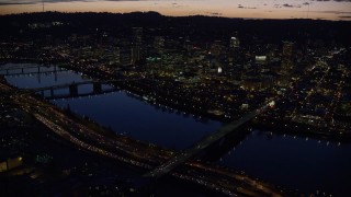 AX155_296 - 5.5K aerial stock footage of Downtown skyscrapers, Burnside Bridge, and White Stag sign at night, Downtown Portland, Oregon